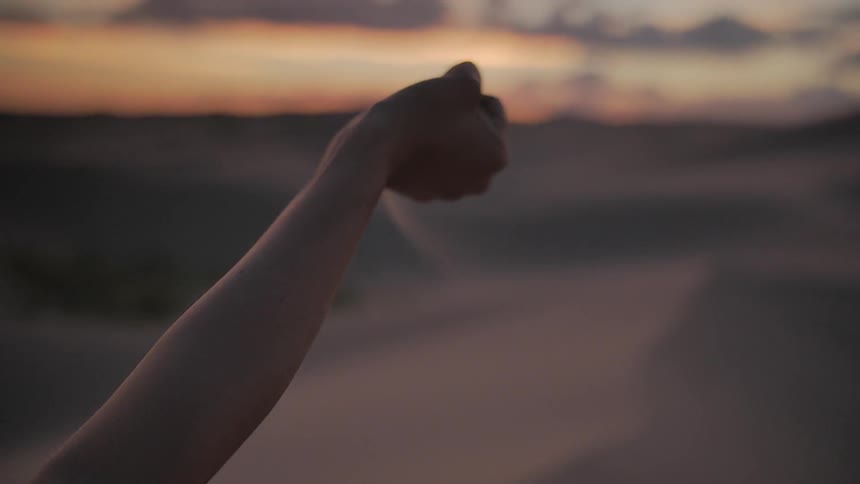A person spills sand from their hand