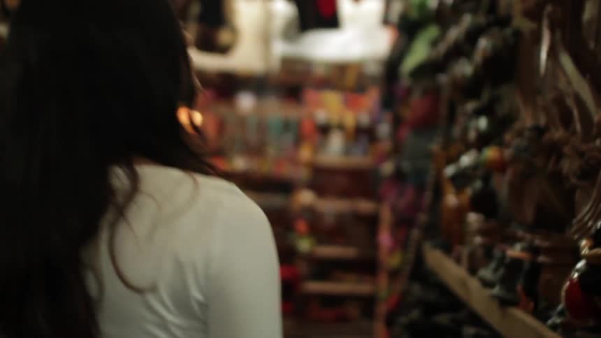 Woman browsing a store with shelves full of items