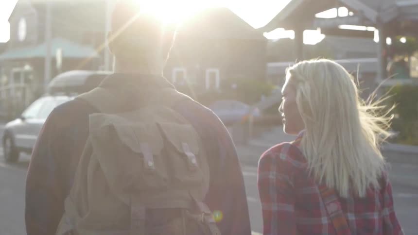 A man and woman walk down a street during the day