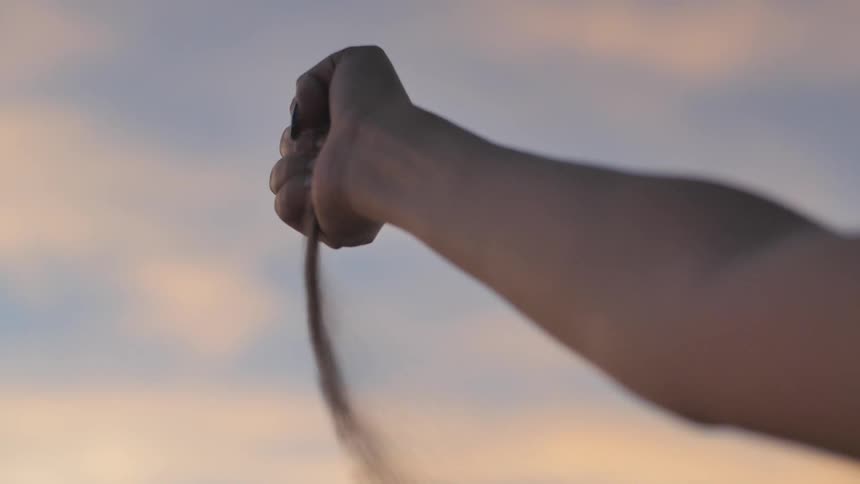 A person releases sand from their hand