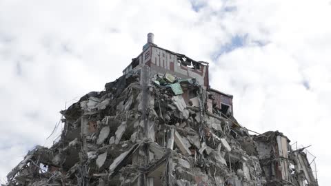 Damaged building sitting high upon other damaged buildings