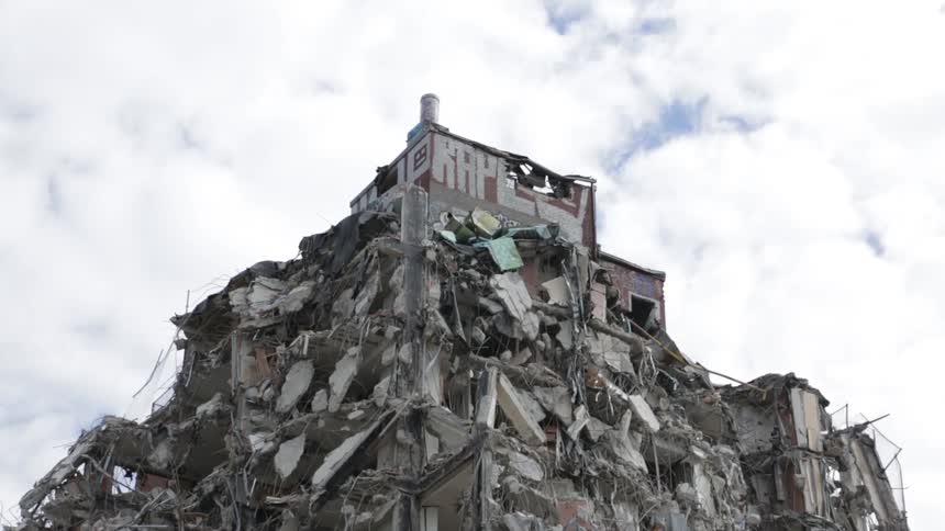 Damaged building sitting high upon other damaged buildings