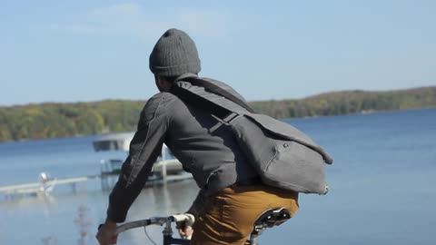 Man riding his bike on a trail by the water during the day