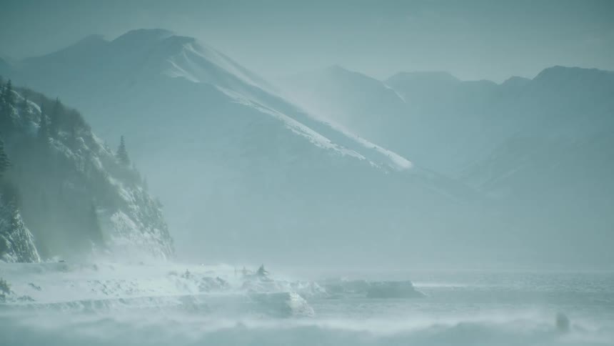 Snow blowing through a mountain landscape