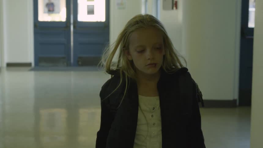 Girl walking down a hallway during the day