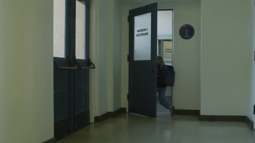 A little girl walks into a woman's restroom