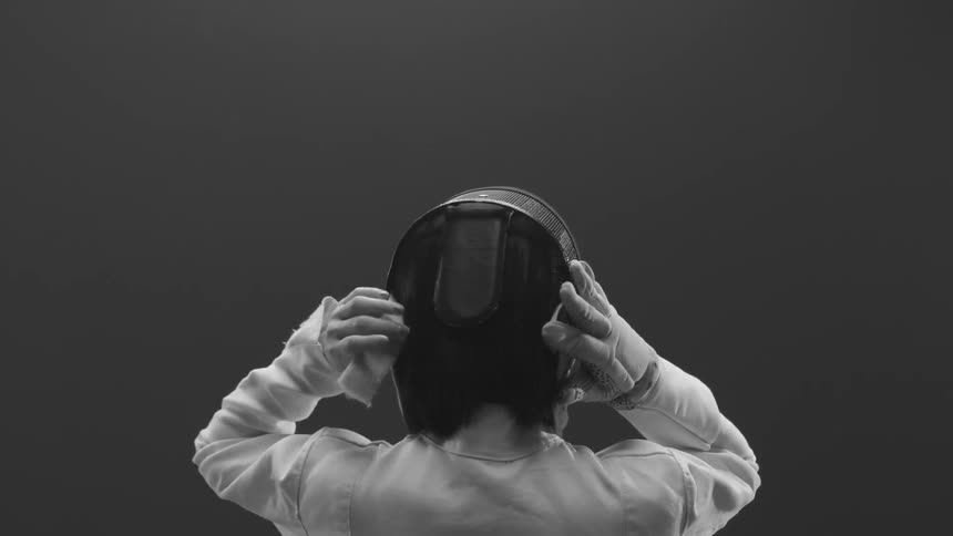 A person putting on fencing gear