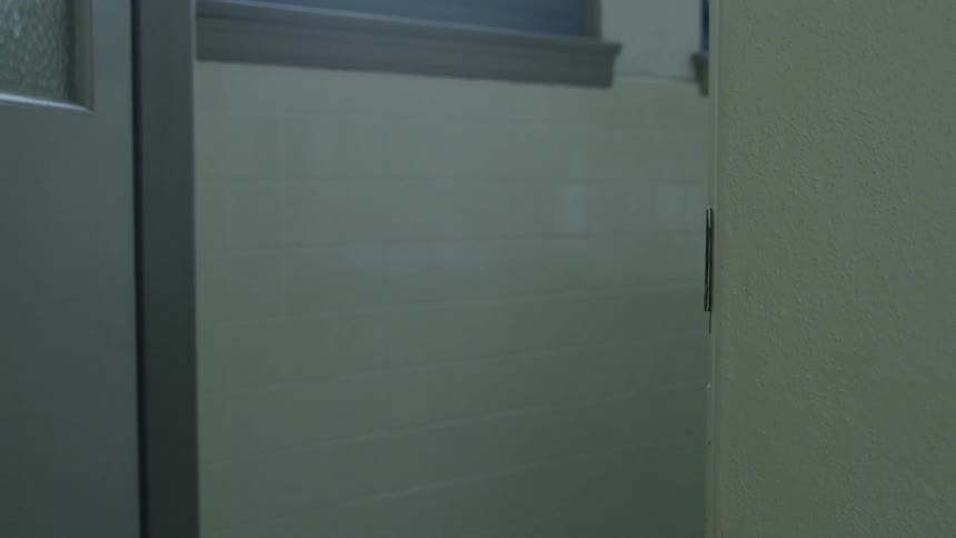 Girl with a blue backpack rapidly going through a door in a school