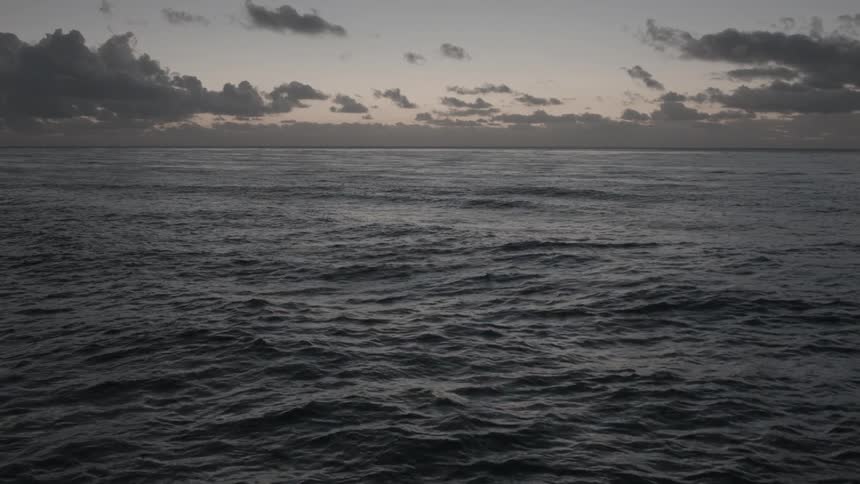 Waves rolling under a cloudy sky