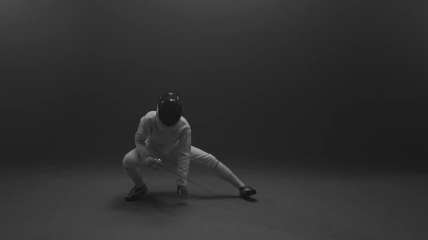 A person wearing fencing gear stretching