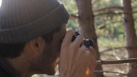 A man takes a picture of a tree