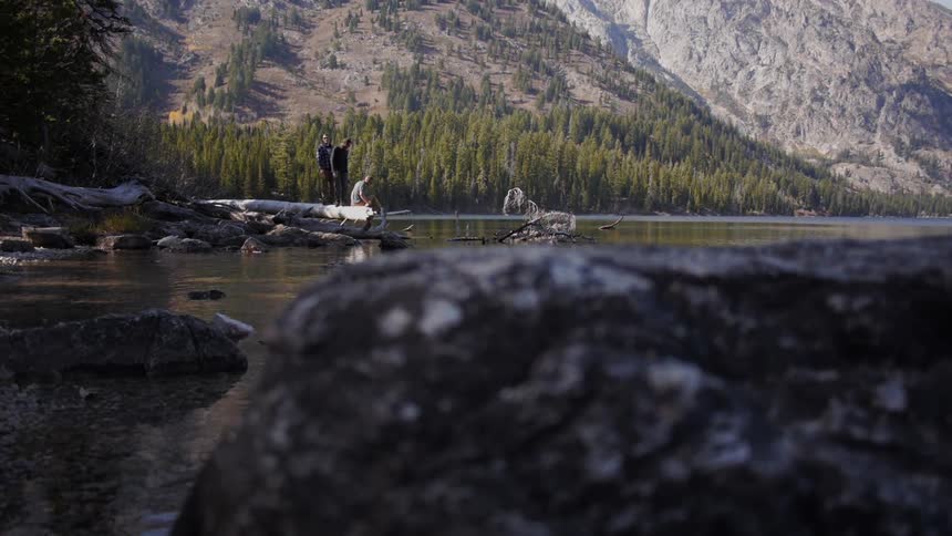 People stand on rocks near a river