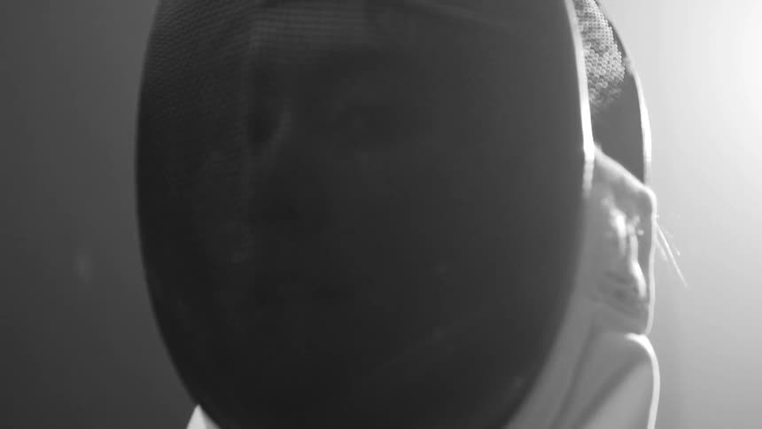 With a strong background light, a person's face is seen inside a helmet