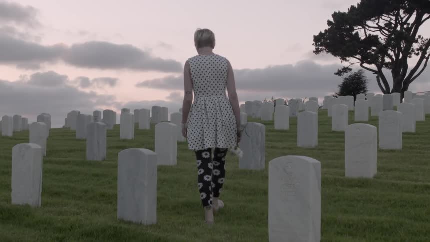 A woman walks through a cemetary