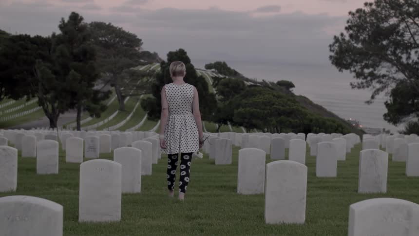 A woman walks through a cemetary