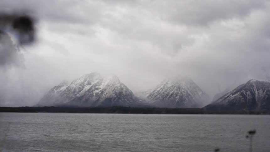 Lake and snow capped mountain range landscape on a cloudy day