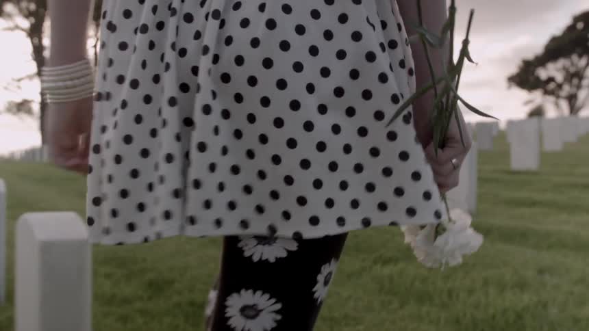 Woman walking through a cemetery on a cloudy day