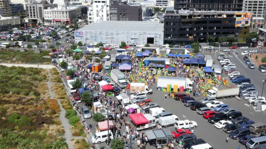 A bird's eye view of a flea market located in a city parking lot