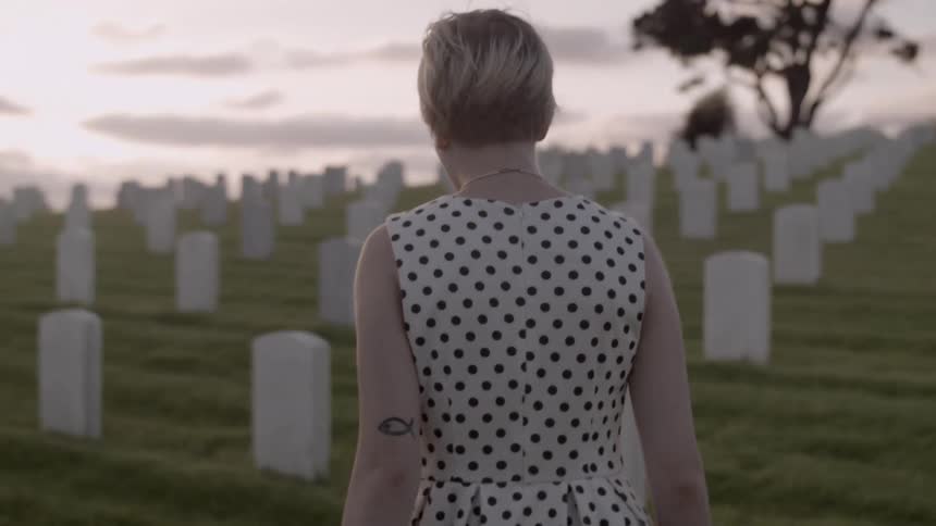 Woman walks through graveyard in the morning