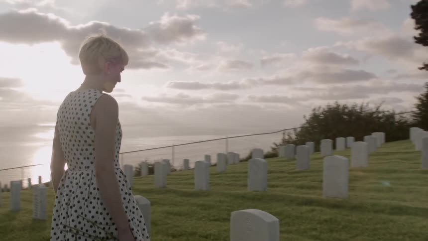 Woman visiting a grave on a cloudy day