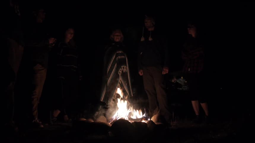 A group of people in front of a small fire
