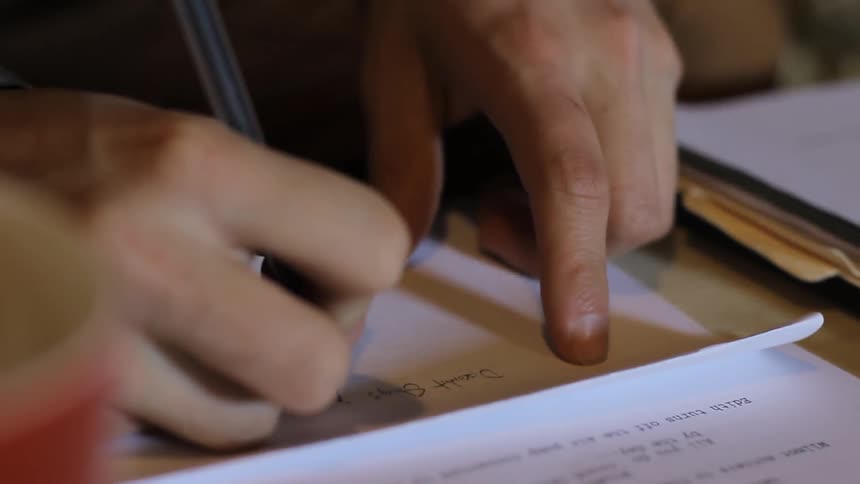 Man writing with a pencil on paper