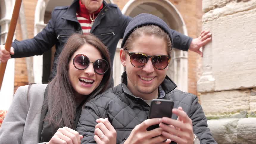 A man and woman take a selfie while on a gondola ride