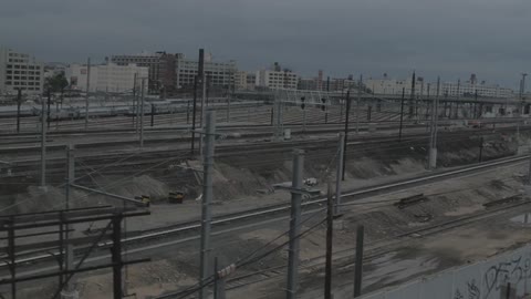 An aerial view of a city street and multiple sets of train tracks
