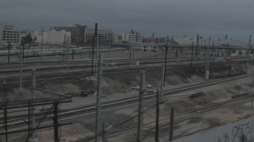 An aerial view of a city street and multiple sets of train tracks