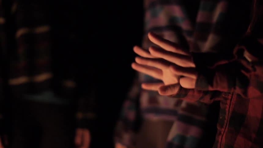People warming their hands over a fire