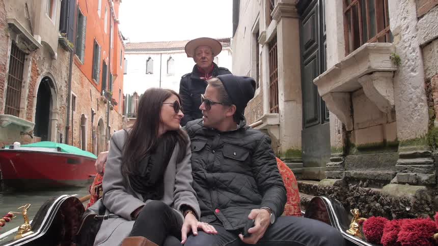 A man and woman kiss on a gondola