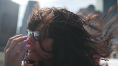 Woman in sunglasses on a windy day