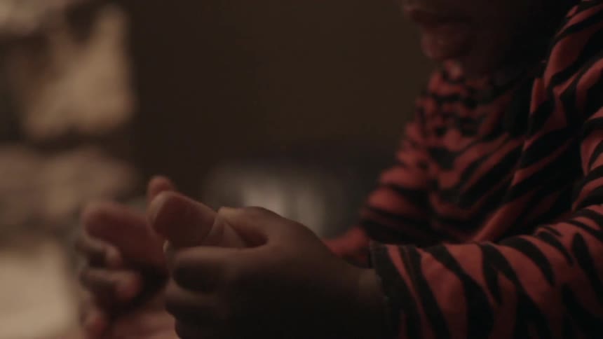 A child holds and adults thumbs as they clap their hands