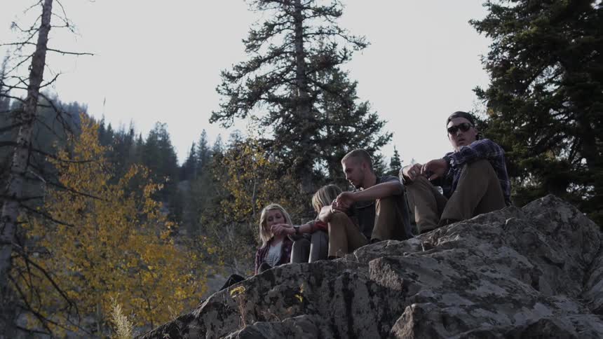 A group of people sitting on a rock