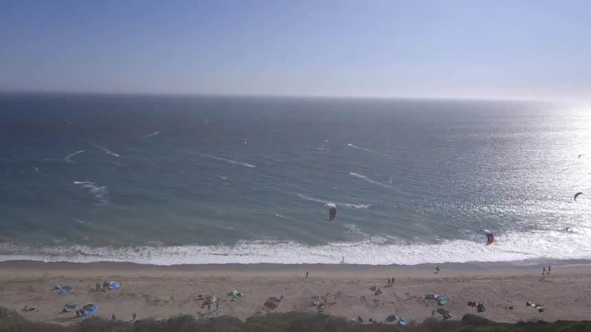 People are flying kites on the beach