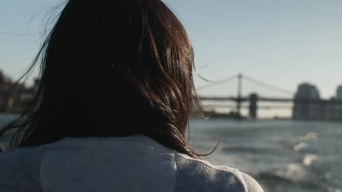 A woman's hair blows while riding in a boat