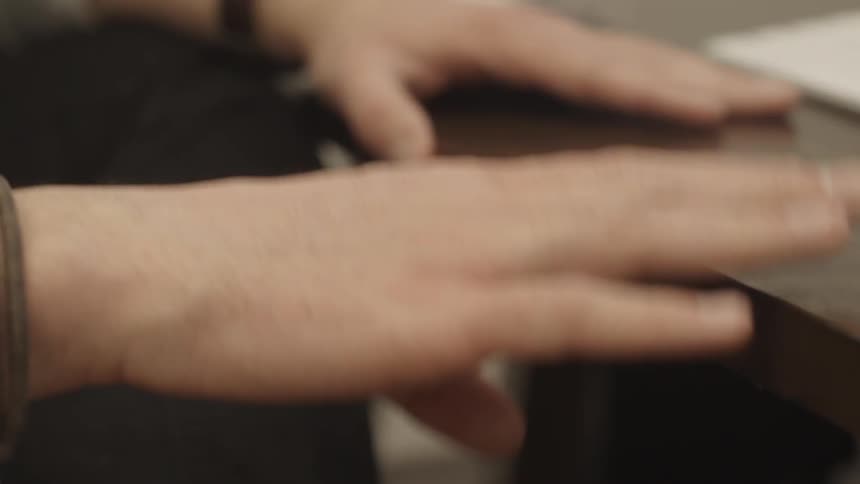 Person drums on a table with hands