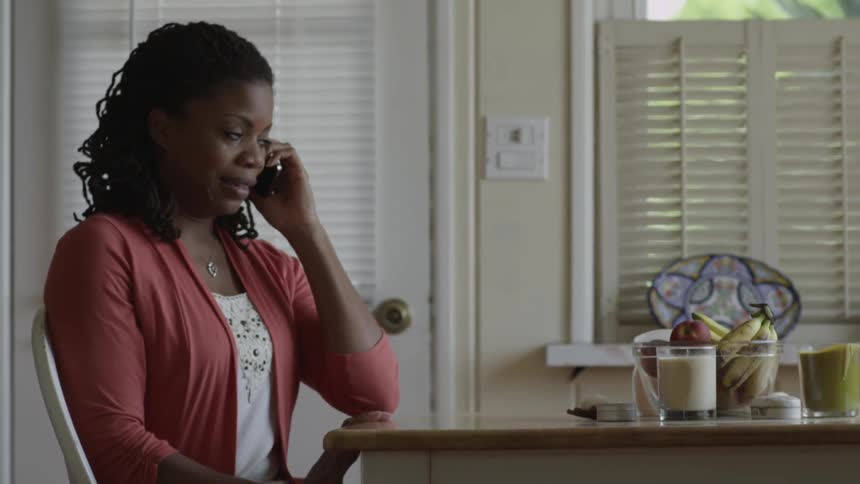 A woman cries as she talks on the phone