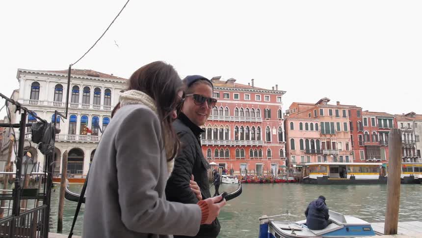 Man and woman walking past a canal on a cloudy day