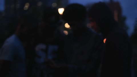 Men stand and look at a phone in the dark