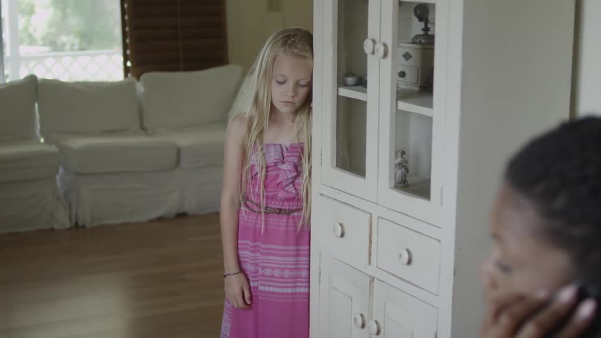 Sad young girl leaning against the cabinet and then walking away