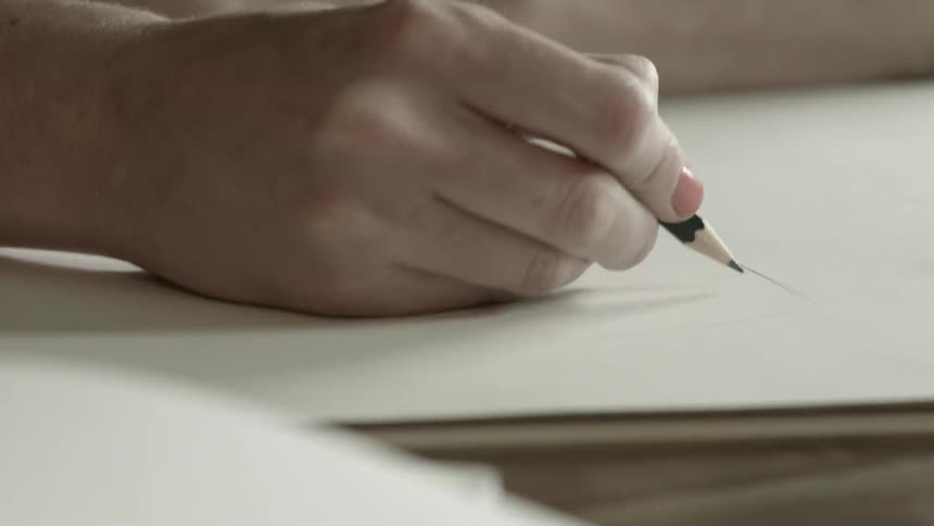 A woman uses a pencil to make a sketch