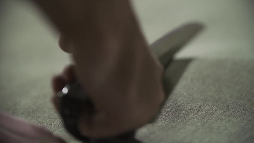 A person cuts material with scissors