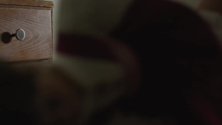 A girl hits her doll on the dresser