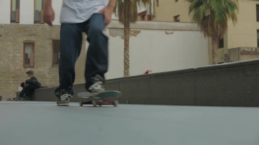 Teenage boy pushes himself along on a skateboard in a park