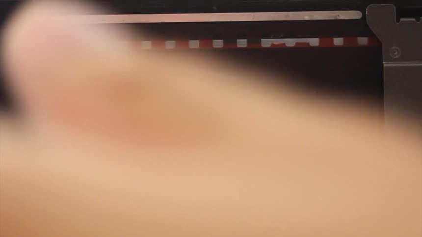 A person touches a film negative