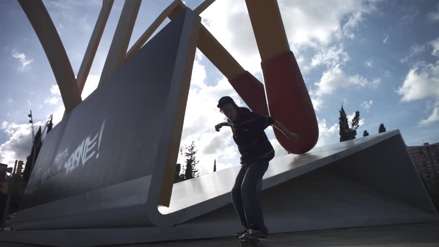 A skateboarder does a trick off a piece of art