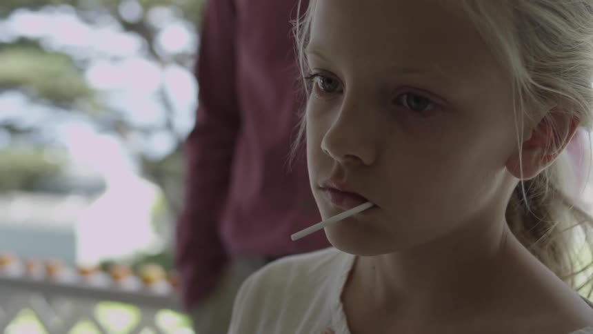 Girl standing outside with a lollipop