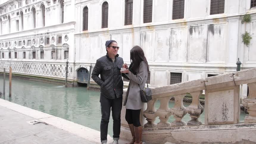 Young couple standing near steps and a canal