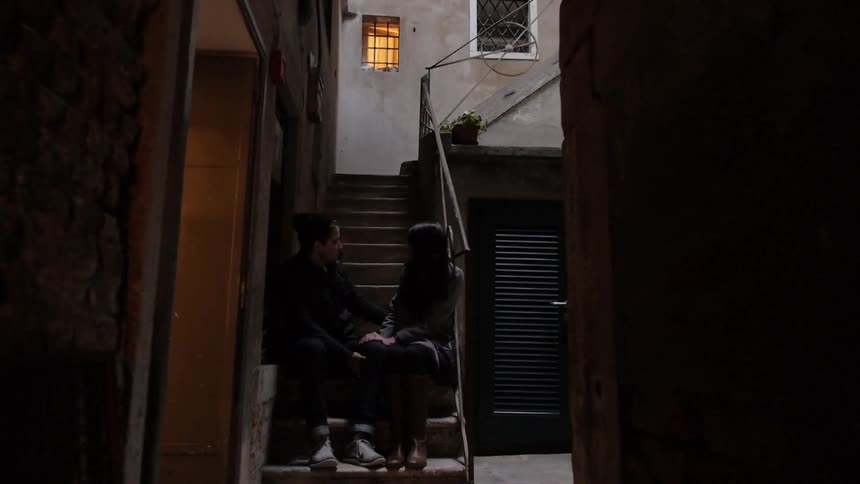Two people sitting in a small alleyway